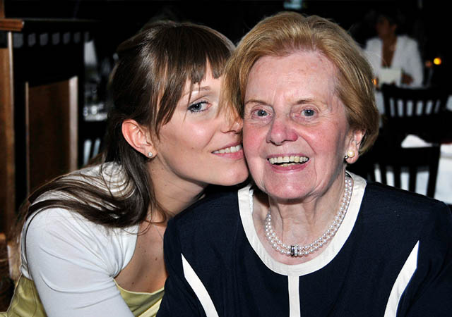 junge frau kuesst ihre oma bei einem abiball