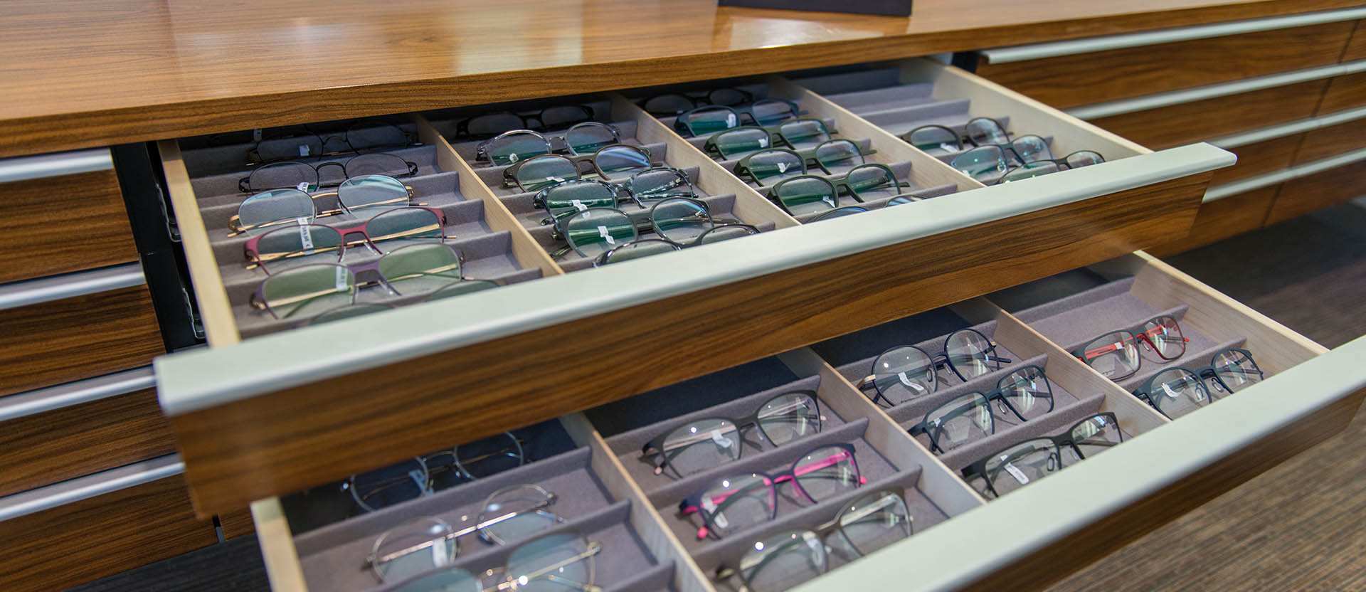 viele brillen liegen in einer auslage beim optiker