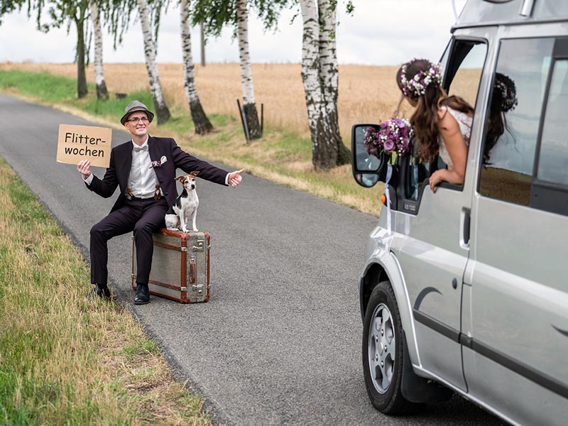hochzeitsfotografie_02 braetigam sitzt auf koffer und wartet mit hund auf die braut